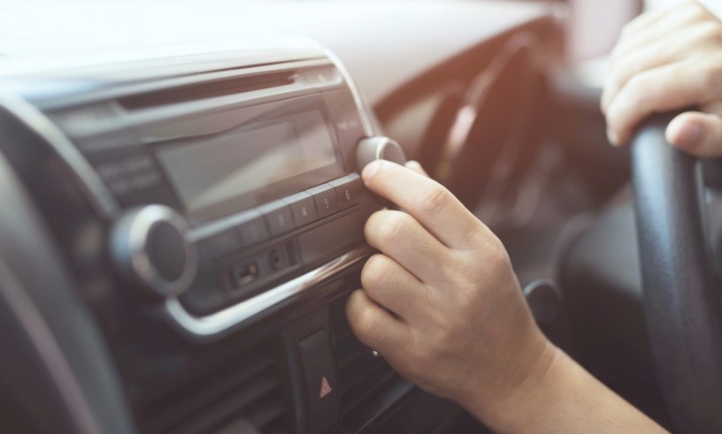 Person tuning radio in car