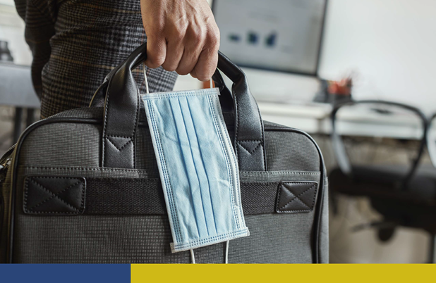 Person holding travel bag with mask