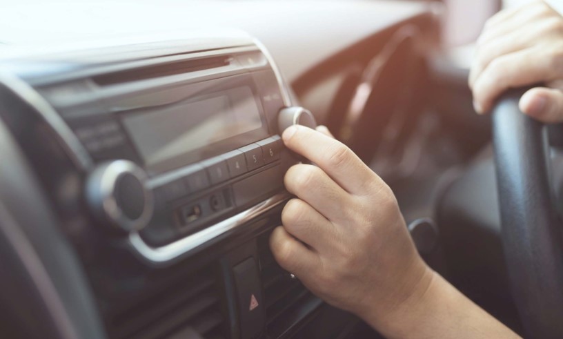 Person Tuning Radio in Car